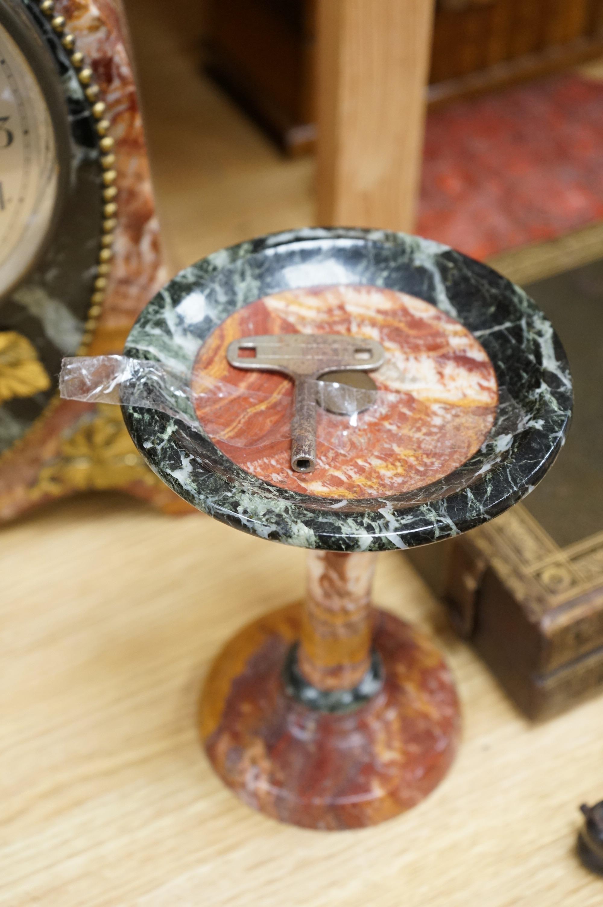 An early 20th century French rouge and black marble clock garniture with ornamental grape motif mounts to the clock and with a key, clock 34.5cm high